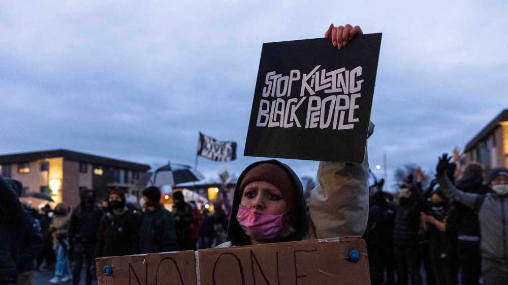 US police fire teargas as anti-racism protesters defy curfew in Minneapolis