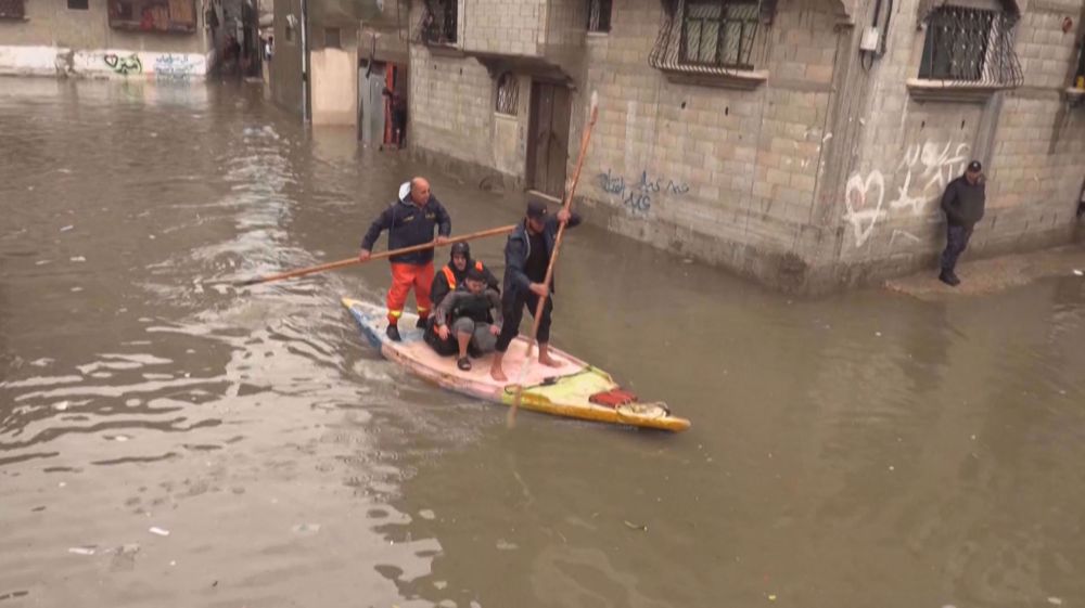 Palestinian rescuers evacuate camp residents from flooded houses