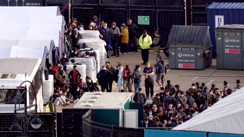 Children among thousands of refugees in prison-like facility in UK