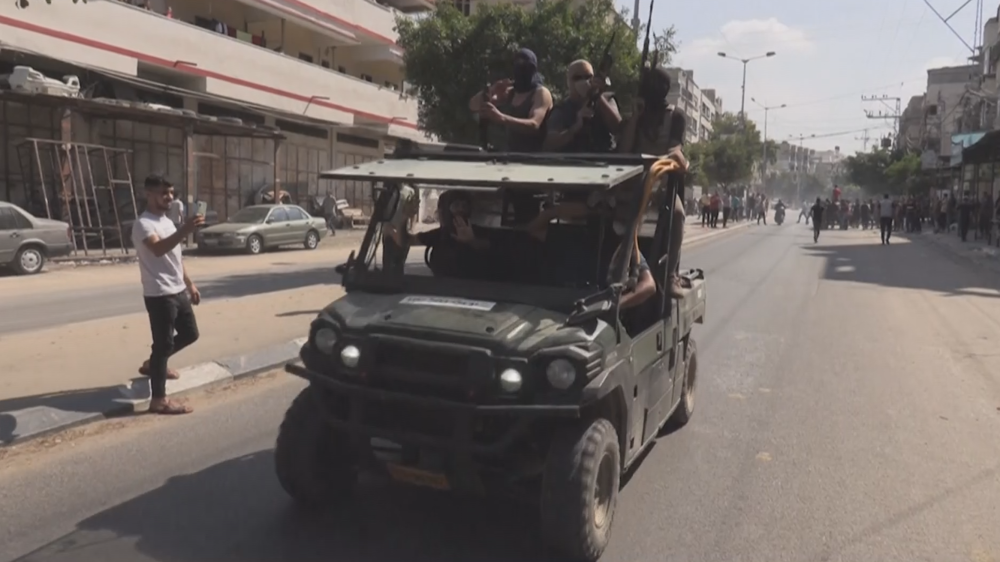 Palestinian fighters parade captured Israeli military vehicles