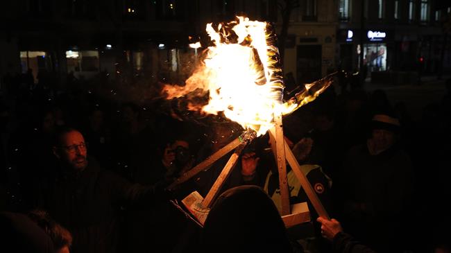 French hold torch-lit protest in Paris against pension reform
