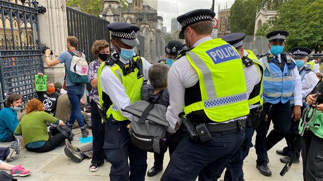 Climate activists glue themselves to street outside British parliament